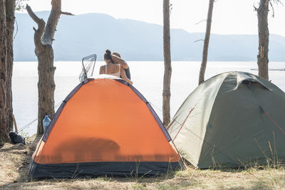Couple by tent at lakeshore