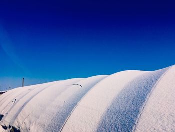 Panoramic view of desert land against clear blue sky