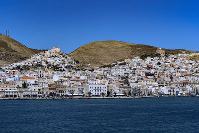 Aerial view of townscape by sea against clear sky