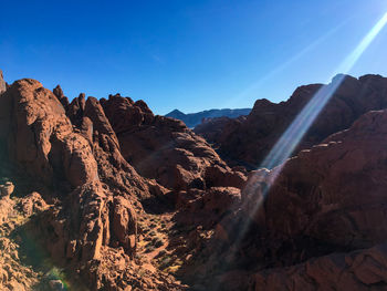Panoramic view of rocky mountains against blue sky