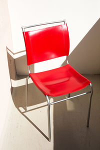 High angle view of empty chair on table against wall