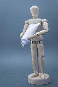 Close-up of figurine on table against blue background