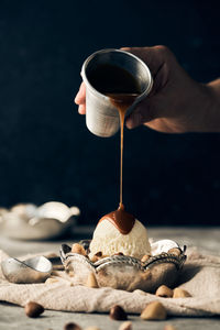 Close-up of hand pouring coffee cup