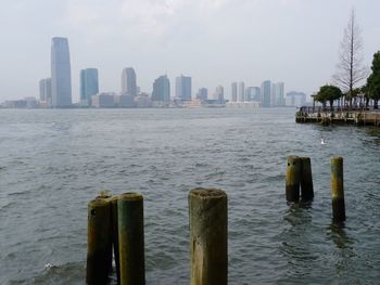 Scenic view of city by sea against sky