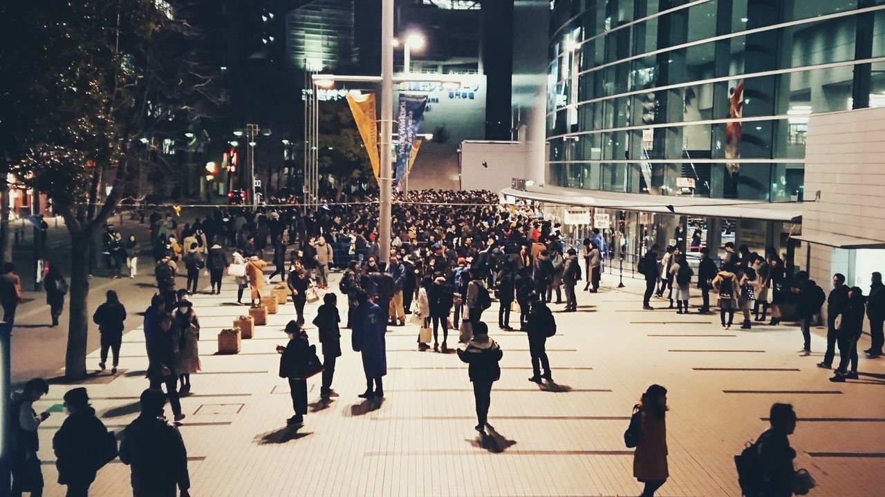 crowd, large group of people, group of people, architecture, city, built structure, building exterior, real people, walking, city life, men, street, women, illuminated, lifestyles, adult, outdoors, building, night