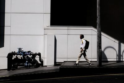 Side view of man standing by window
