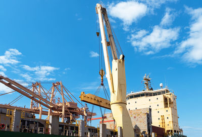 Low angle view of crane against sky