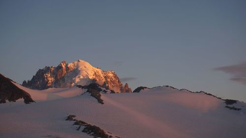 Scenic view of snowcapped mountains against clear sky during winter