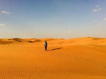 Full length of woman on sand in desert against sky