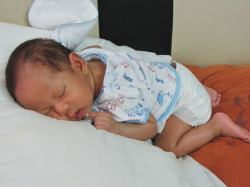 Cute baby boy sleeping on bed