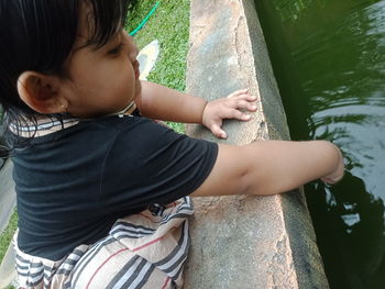 Side view of cute girl looking at water