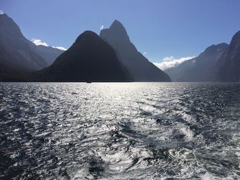 Scenic view of sea and mountains against sky