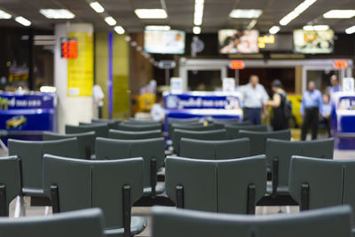 Empty chairs with people in background