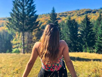 Rear view of woman against plants on field