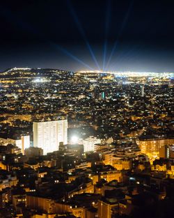 Illuminated cityscape against sky at night