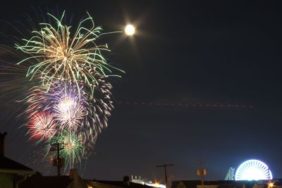 Low angle view of illuminated fireworks against sky at night