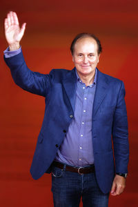 Portrait of smiling man standing against red background