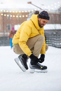 Man tying shoelace on snowy land