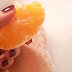 Close-up of hand holding orange