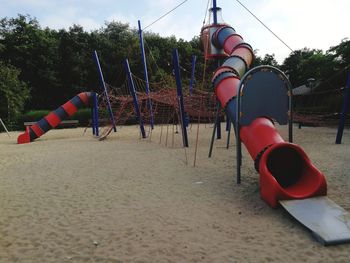 Empty chairs on beach against sky