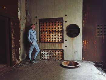 Portrait of man standing by wall