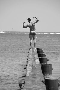 Man flexing muscles at beach