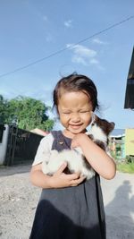 Boy with dog against sky