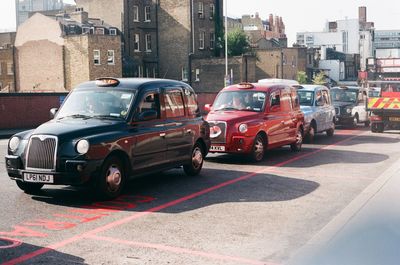 Vehicles on road by buildings in city