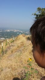 Close-up of boy by sea against clear sky