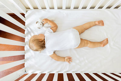 High angle view of child relaxing on bed at home