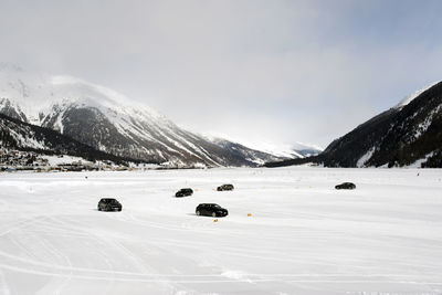 A panorama view of snowy landscape and mountains and cars on the snow in the alps switzerland