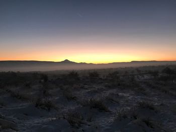 Scenic view of landscape against clear sky during sunset