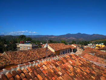 Houses in town against clear blue sky