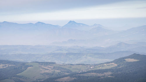 Autumn landscape with valley and big mountains disappearing in fog in the background, europe