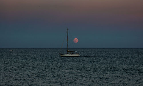 Boat in sea against dramatic sky