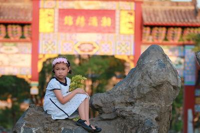 Portrait of a girl sitting on rock