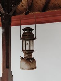 Low angle view of lantern hanging on roof against sky