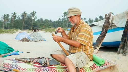 People sitting at beach against sky