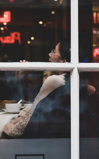 Woman sitting by window at store