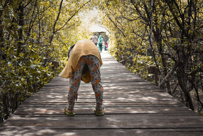 Rear view of person riding on footpath