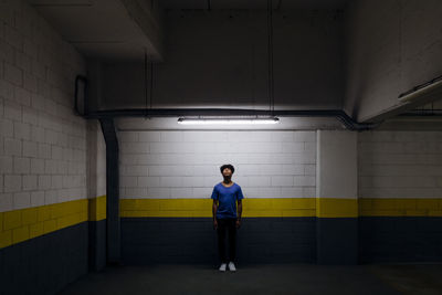 Young man looking at led light standing in subway