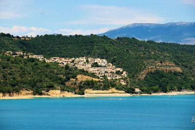 Scenic view of townscape by sea against sky