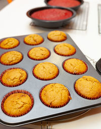 High angle view of cupcakes in baking sheet on table