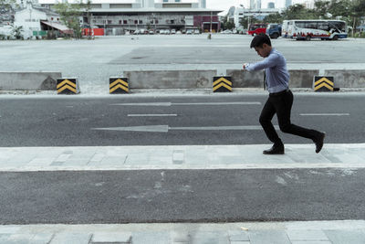 Full length of man crossing road