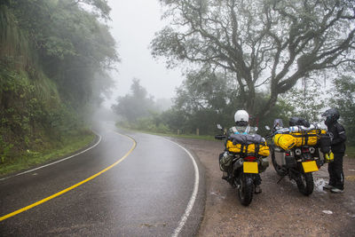 Two women with touring motorbikes in rain forest, jujuy / argentina