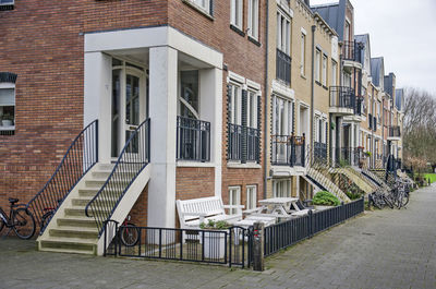 Empty benches on footpath by buildings in city