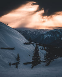 Scenic view of snowcapped mountains against sky during sunset