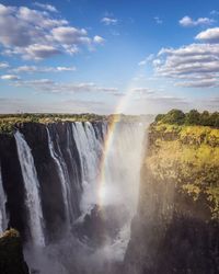 Scenic view of waterfall against sky