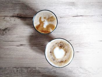 Directly above shot of two coffee glasses on wooden table
