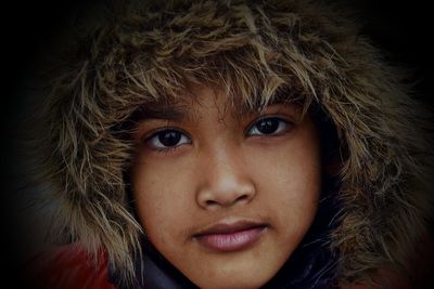 Close-up portrait of boy wearing fur coat